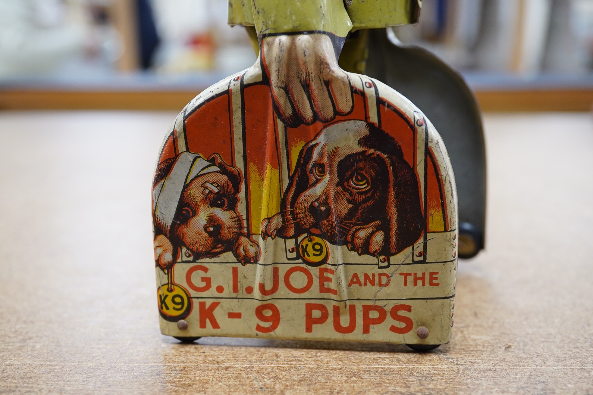 A 1940s clockwork tinplate G.I. Joe and his K-9 Pups by Unique Arts Manufacturing Company Inc, New York. Condition - fair to good.